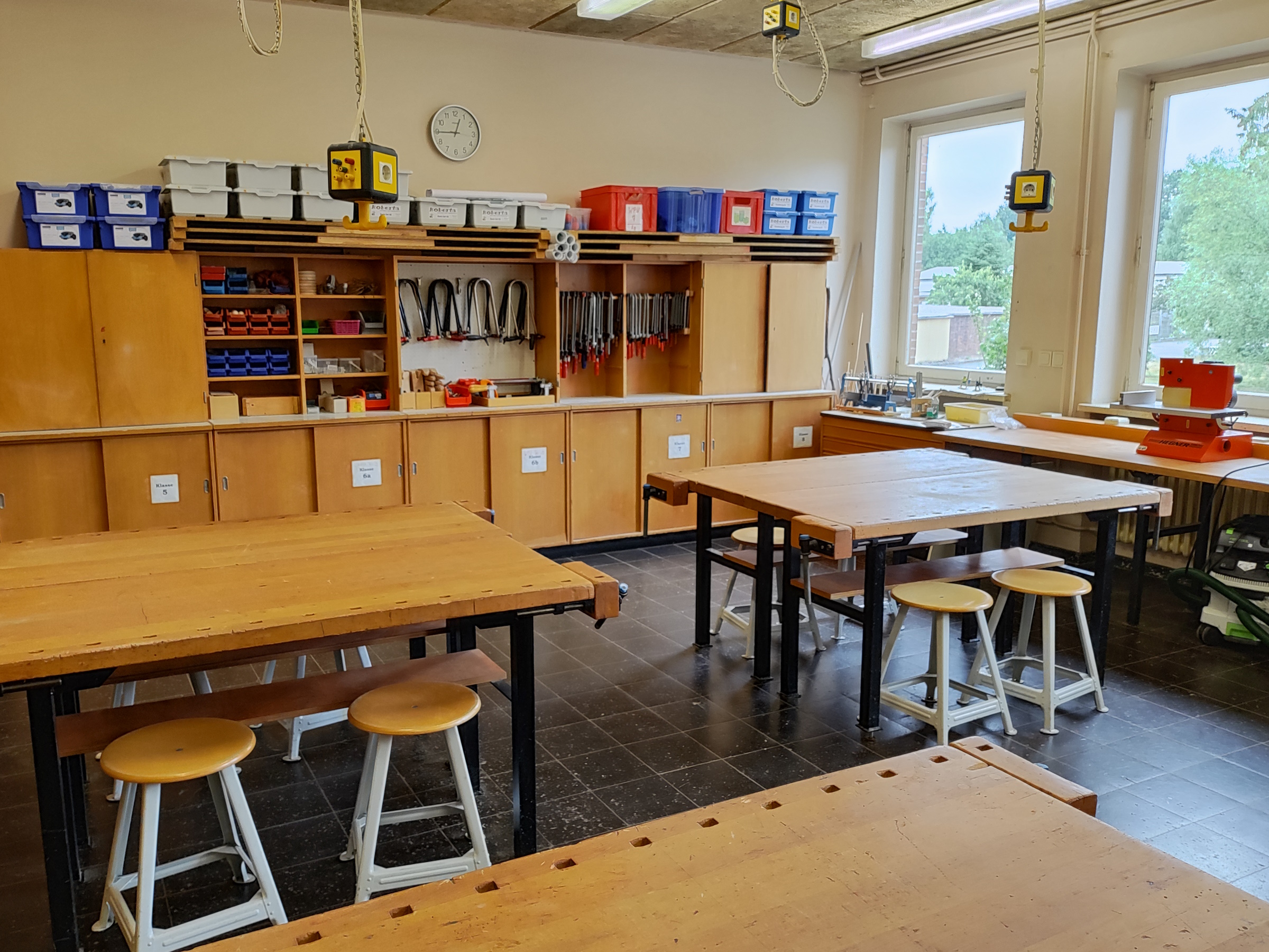 Blick in den Technikraum einer Schule. Werkbänke und Schränke mit Werkzeugen und Kisten